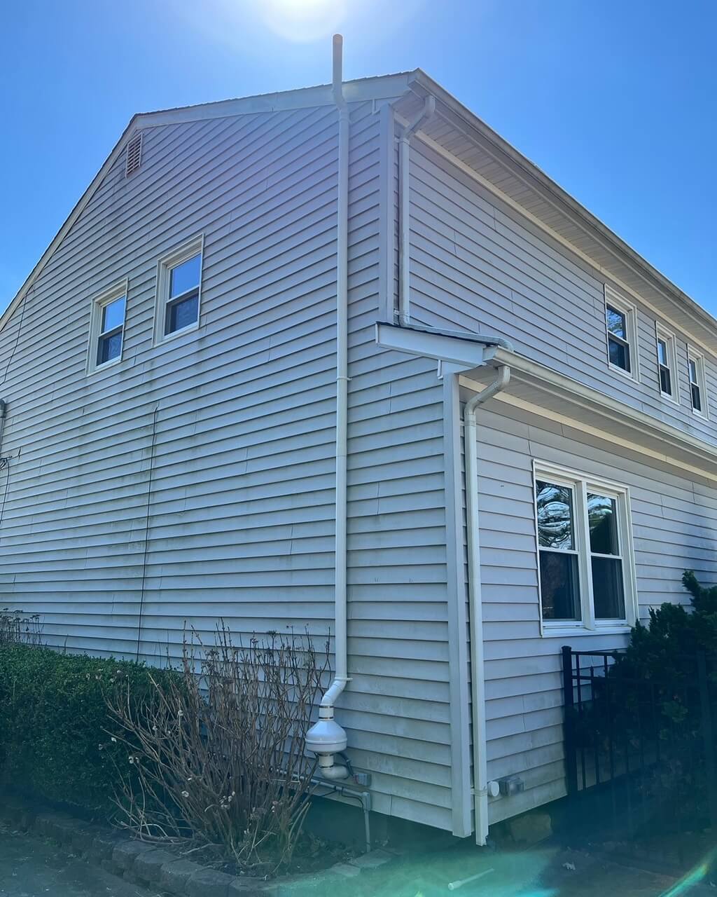 Exterior shot of a radon mitigation system with exhaust pipe